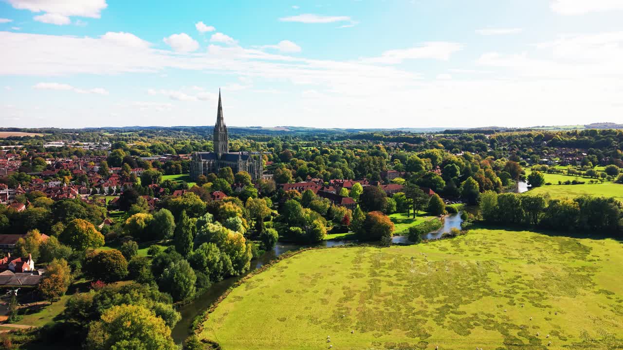Veduta aerea con drone della Cattedrale di Salisbury circondata dagli storici prati umidi e dal fiume Avon nel Wiltshire, Inghilterra. Scenografico paesaggio della campagna inglese con la famosa guglia della cattedrale che si innalza.