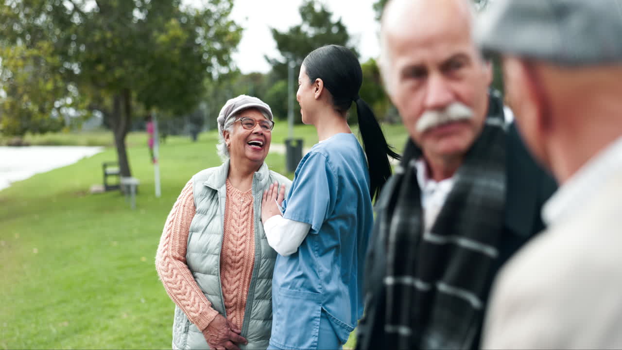Nurse talking with elderly people in the park