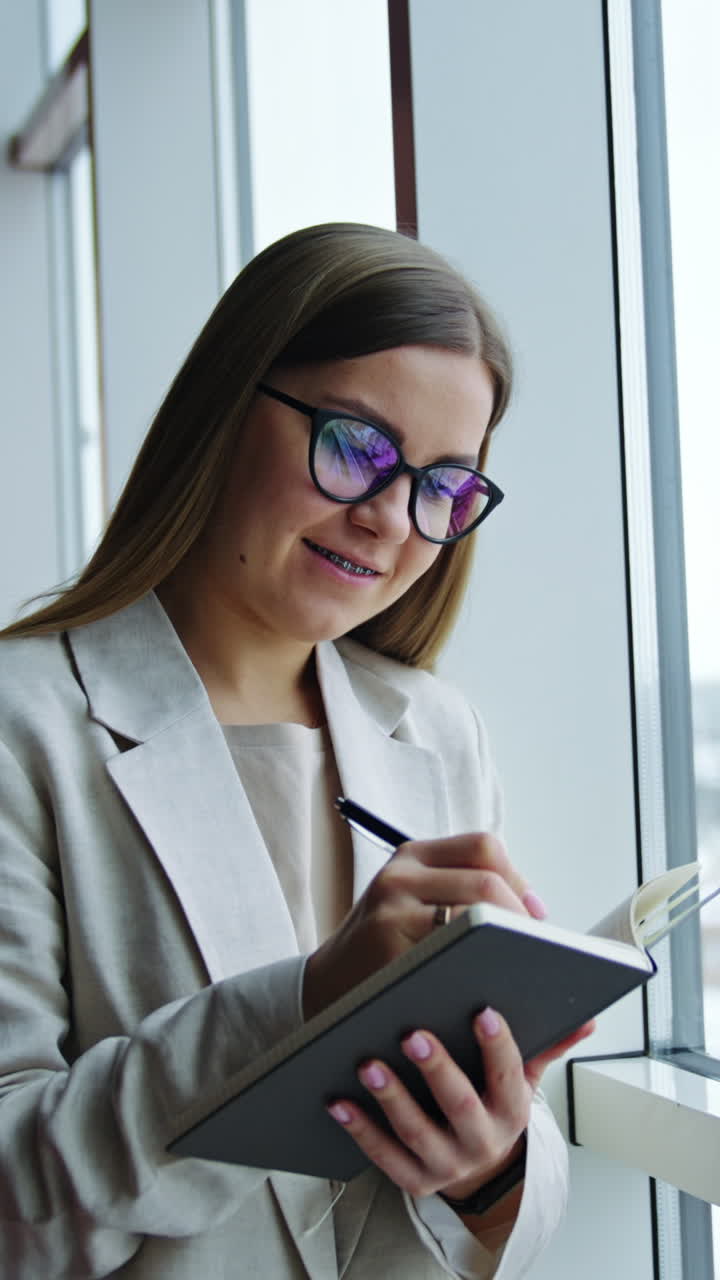 Woman Taking Notes by Window