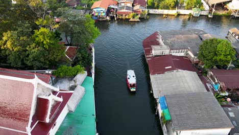 Aerial-View-Over-Khlong-Bangkok-Yai-Canel-Waterways-With-Small-Boat-Passing-By