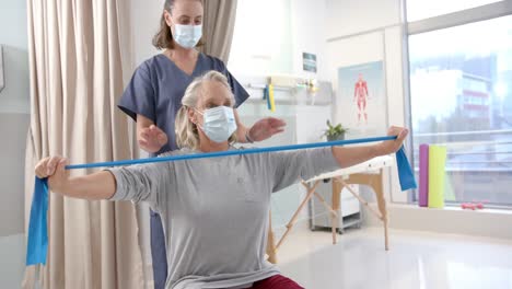 caucasian female physiotherapist and female senior patient with prosthetic leg exercising