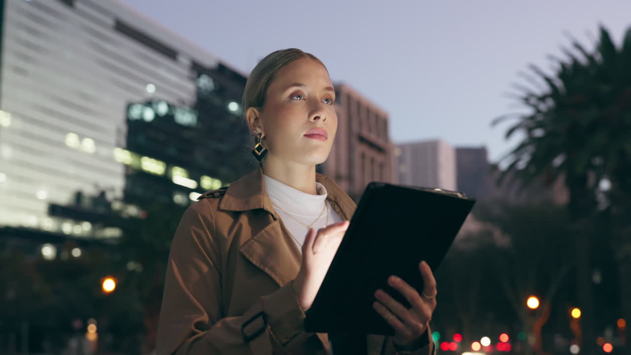 Businesswoman using tablet in city at night