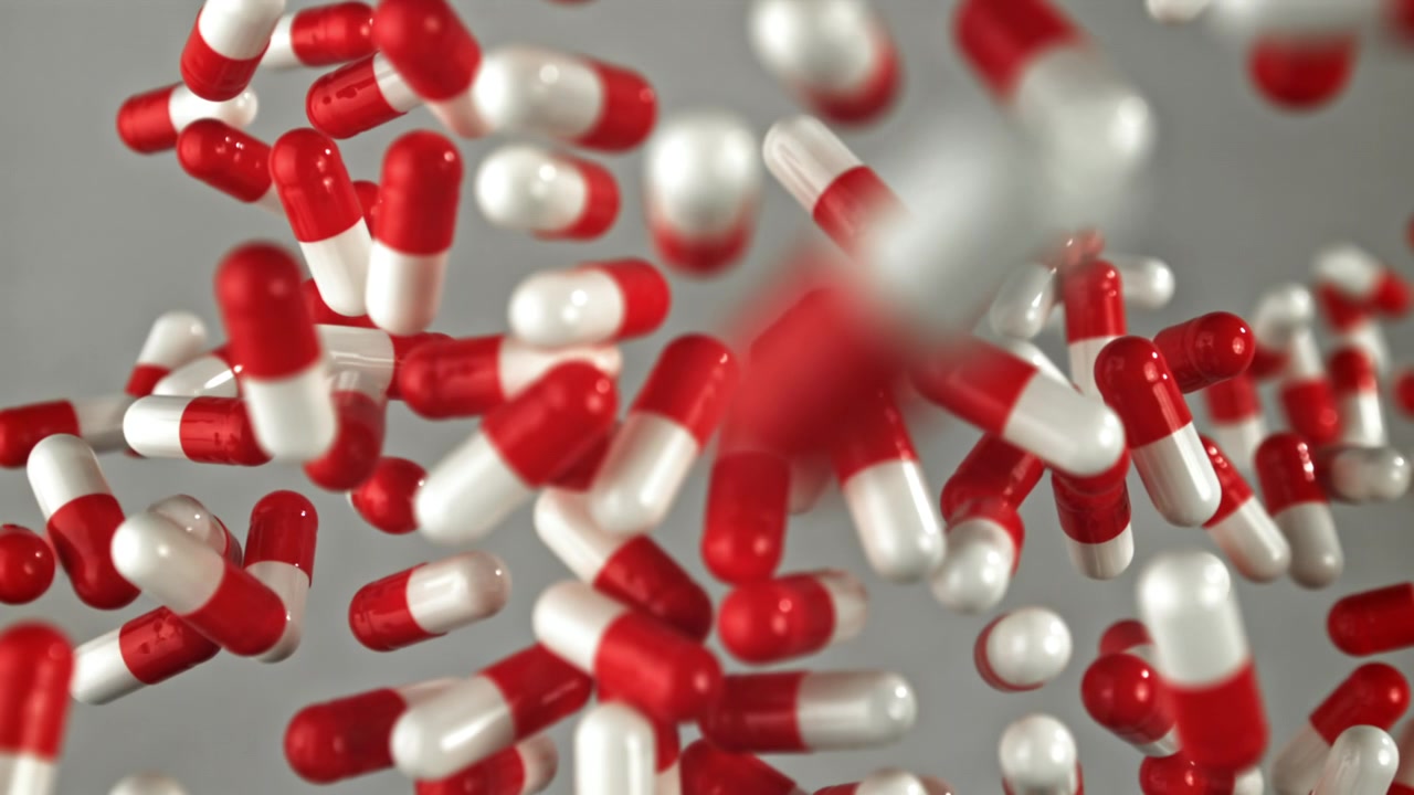 Capsule mediche rosse e bianche che cadono al rallentatore