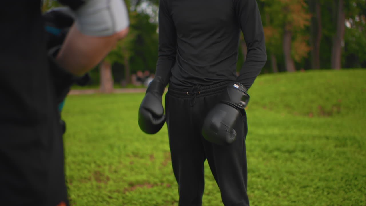 Boxeadores praticam em parque durante a manhã. Lutadores se preparam com equipamentos ao ar livre ao amanhecer. Treinamento matinal ao ar livre onde atletas trocam equipamentos e praticam boxe em ambientes com ar fresco
