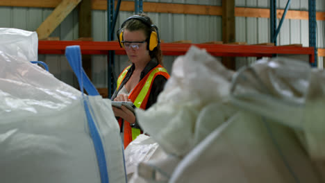 Front-view-of-caucasian-female-worker-working-on-digital-tablet-in-warehouse-4k