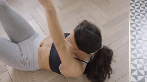 mujer ejercitando abdominales en el piso
