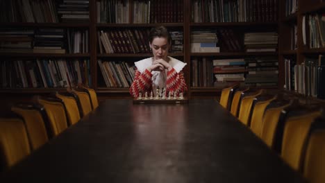 mujer jugando al ajedrez en una biblioteca