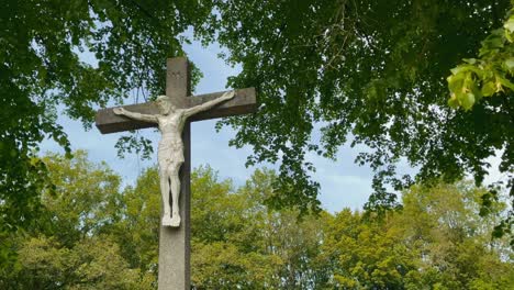 la estatua de jesús cuelga en una cruz de hormigón en limburgo durante la primavera en un bosque