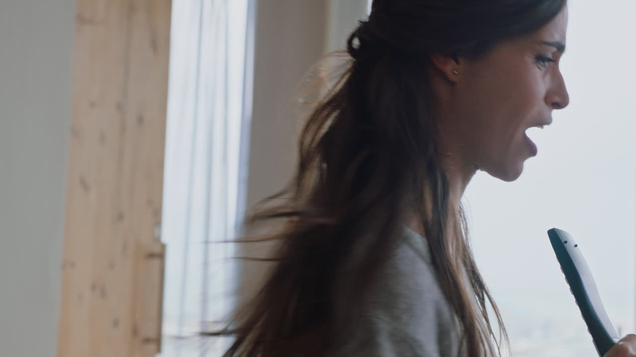 행복한 인도 여성은 집에서 노래하고 즐겁게 성공적인 라이프 스타일을 축하하고 춤을 추고 카라오케 음악 엔터테인먼트를 즐기고 있습니다.