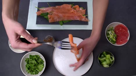 chef preparing salmon dish with dressing, greens, and grapefruit ingredients