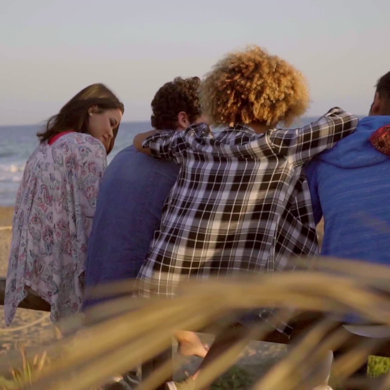 jóvenes sentados en una valla de madera