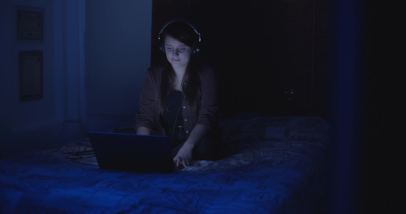 Woman with headphones on at night