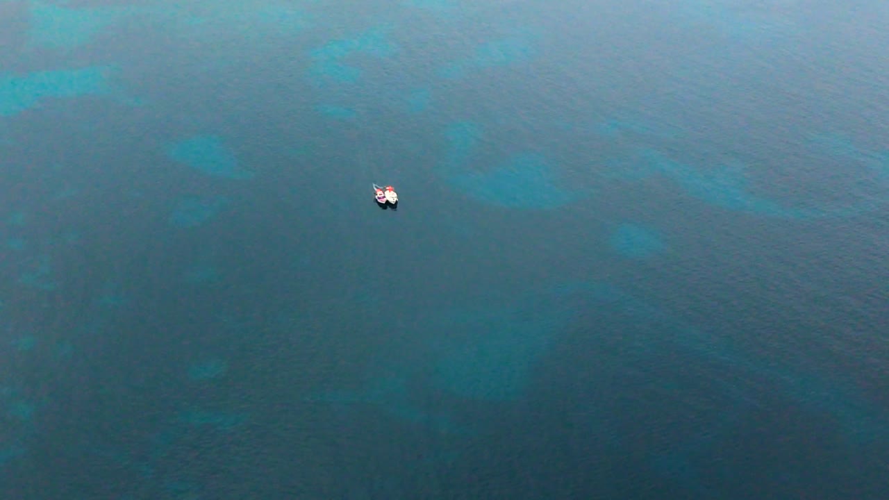 Low drone view of two small boats over the sea off Porticello, Sicily, where the luxury yacht Bayesian sank in 2024 near Palermo in the Mediterranean