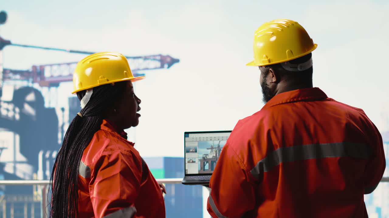 Vertical video Offshore platform employees use management software to observe operations
