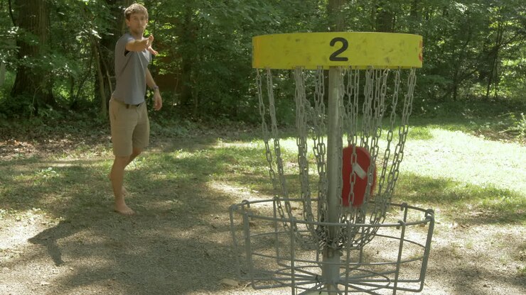 Man Scores a Basket in a Round of Disc Golf in the Woods and Celebrates in Slow Motion
