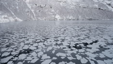 POV-Aufnahmen-Einer-Winterlichen-Bootsfahrt-Durch-Den-Norwegischen-Geirangerfjord,-Mit-Atemberaubenden-Ausblicken-Auf-Das-Eis-Im-Wasser-Von-Den-Umliegenden-Schneebedeckten-Bergen-Aus