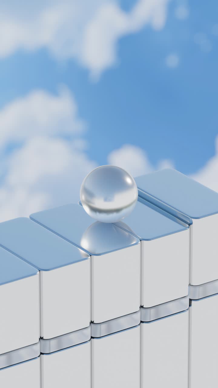 A reflective ball on chrome blocks against a cloudy sky