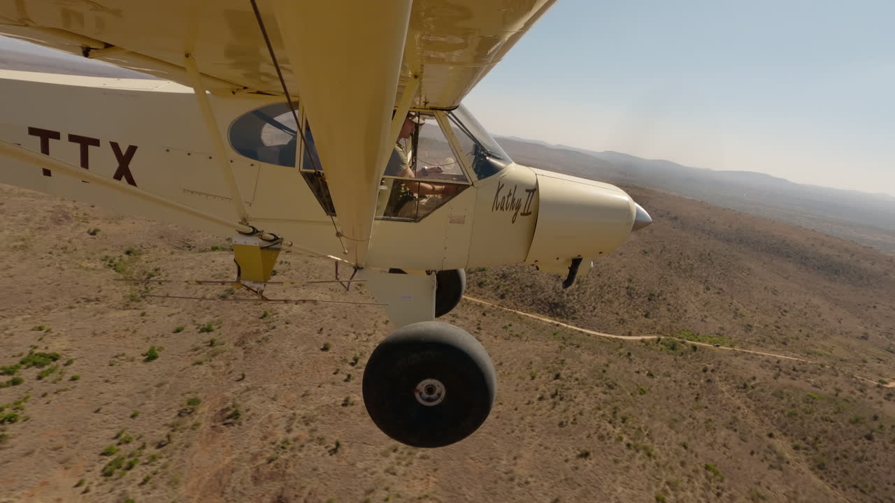 Piccolo aereo bushcraft in volo sopra una strada sterrata nella savana