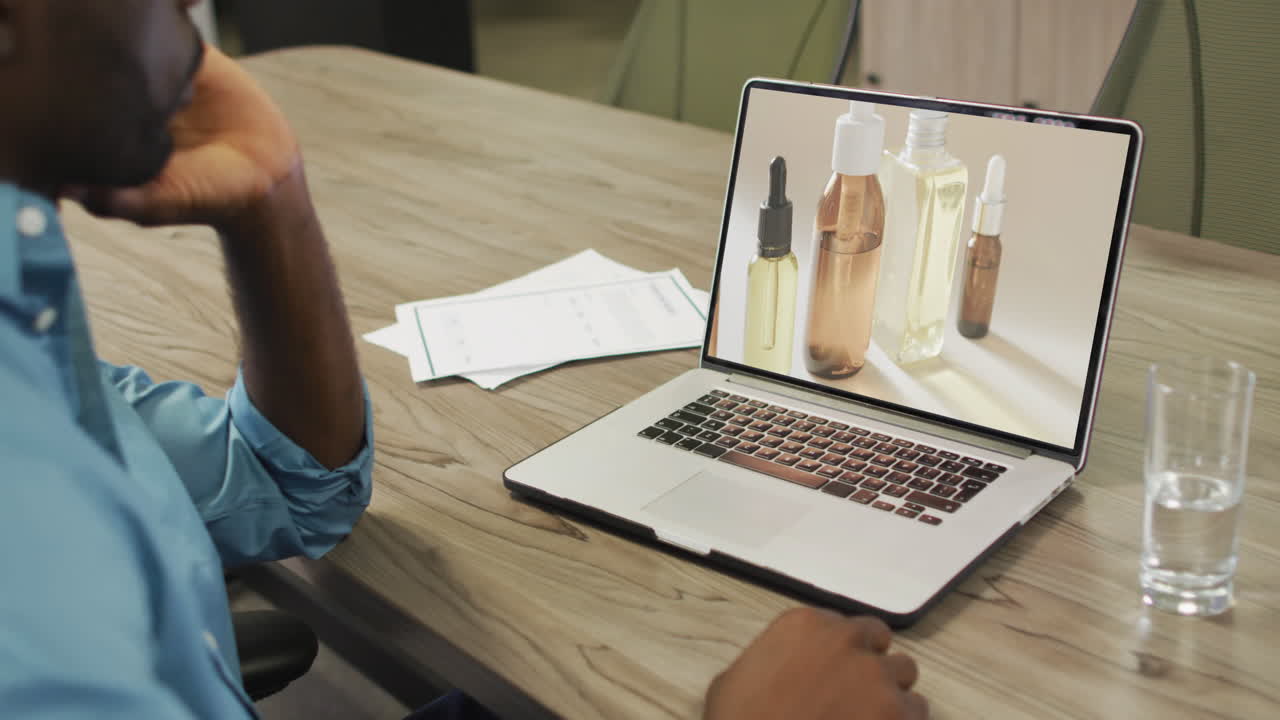 African american man at table, online shopping for beauty products, slow motion