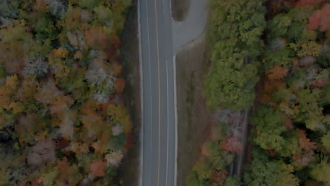 Vista-De-Pájaro-De-Arriba-Hacia-Abajo-De-La-Carretera-Kancamagus-Vacía-Y-El-Follaje-De-Otoño