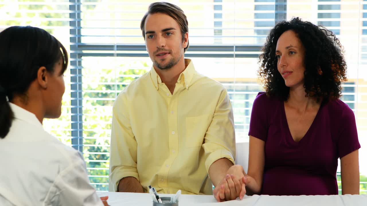 pareja hablando con el médico en la clínica