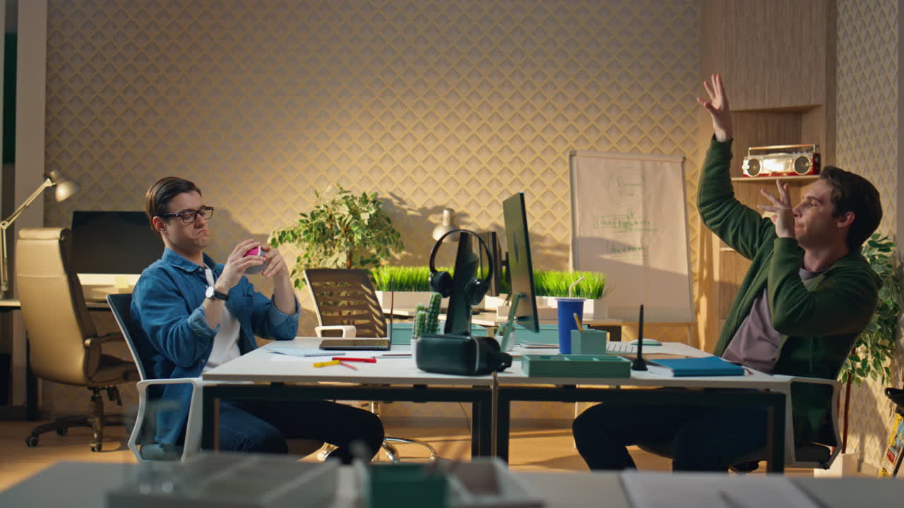 расслабленные фрилансеры бросают мяч, разговаривают в офисе. два умных человека общаются.