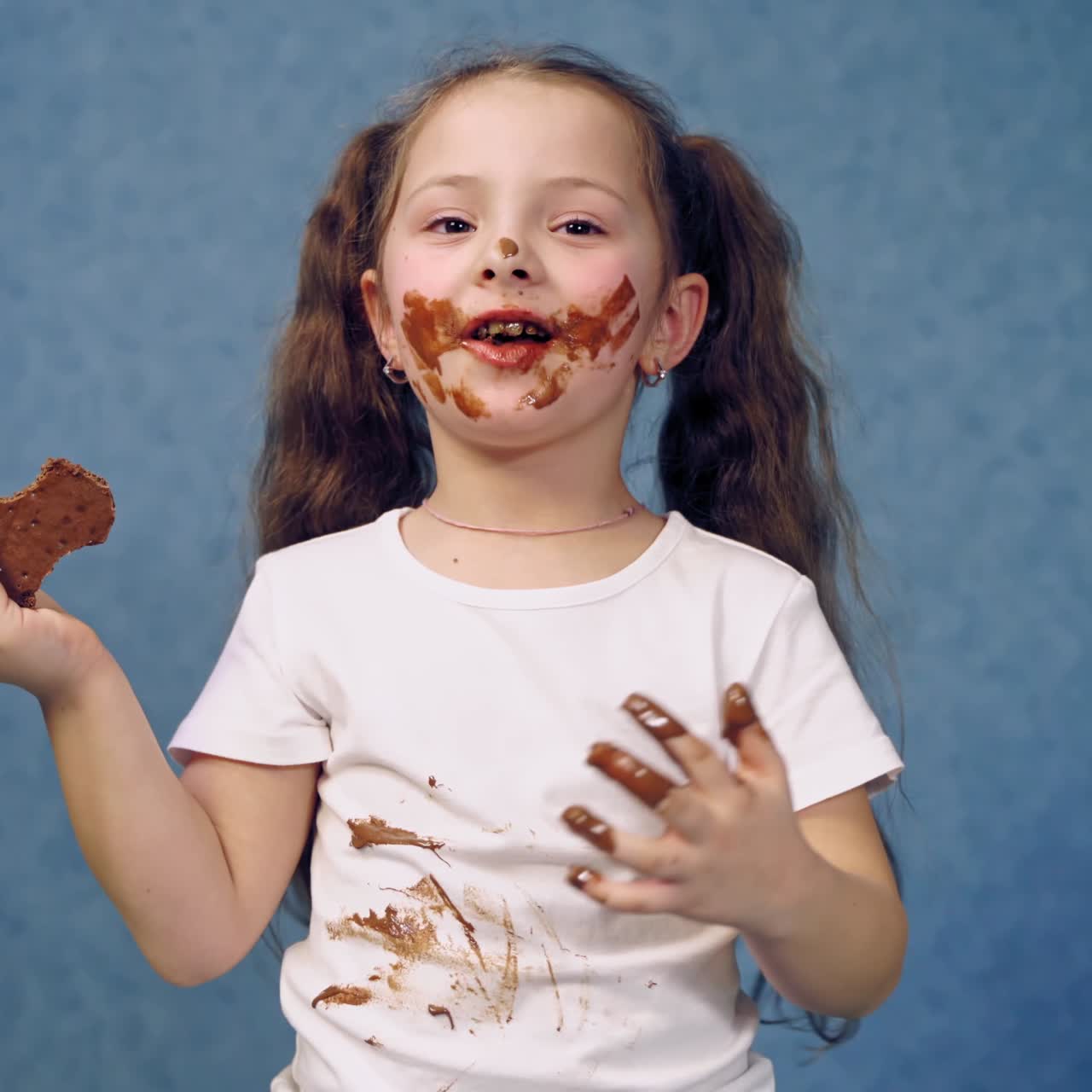 . Girl with chocolate plate. Little girl eating chocolate plate on table