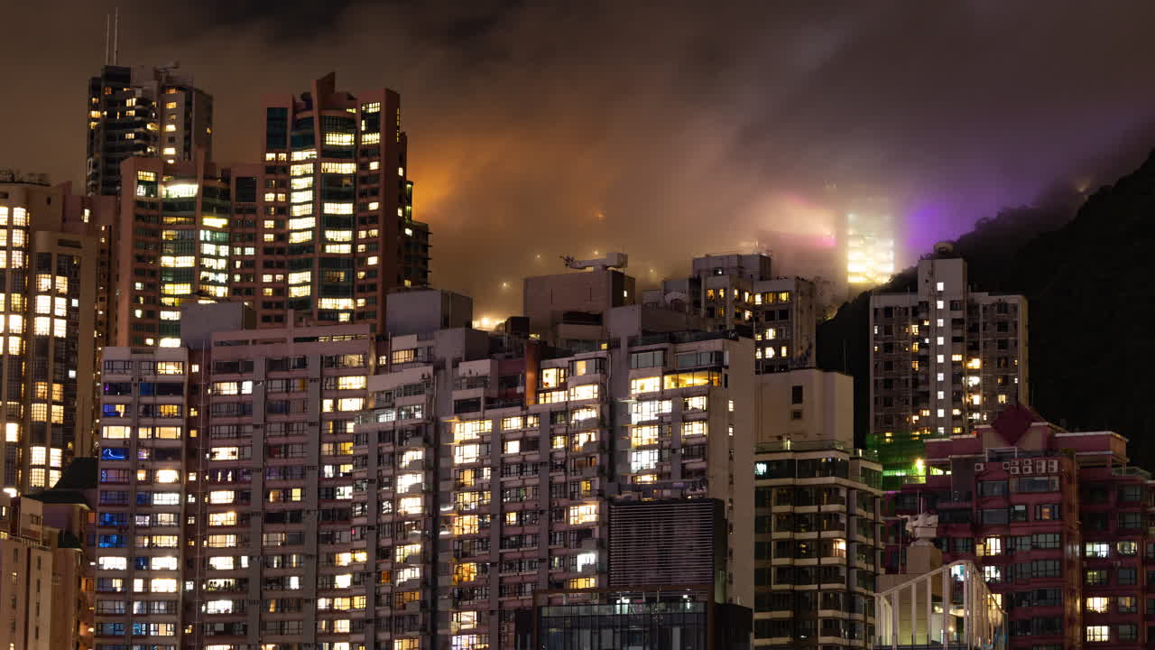 HONG KONG - 19 MARCH 2025 : Timelapse of the Hong Kong city skyline at night with the peak in the background