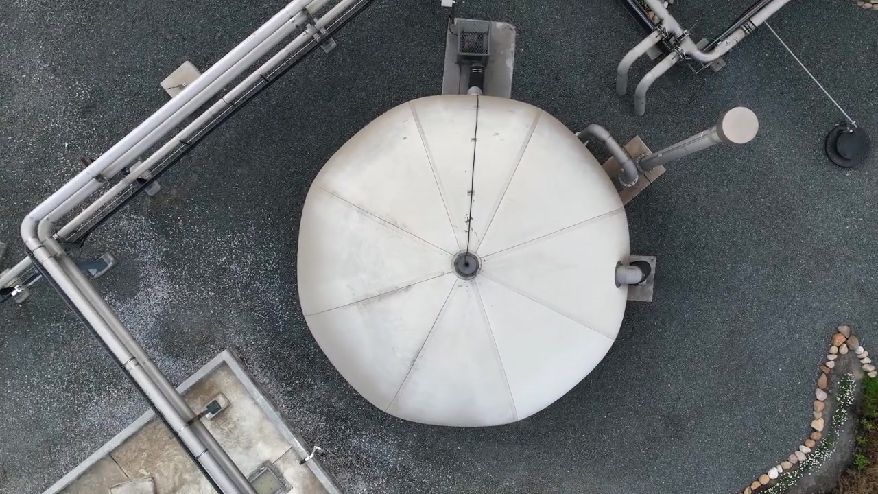 Luftoptagelse af cirkler over en membrangasbeholder i biogasproduktion.