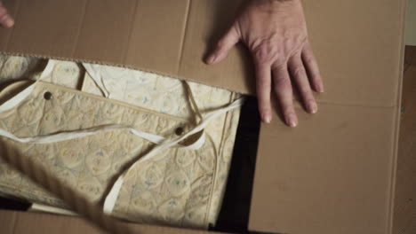 person closes the cardboard box full of books and documents and leaves