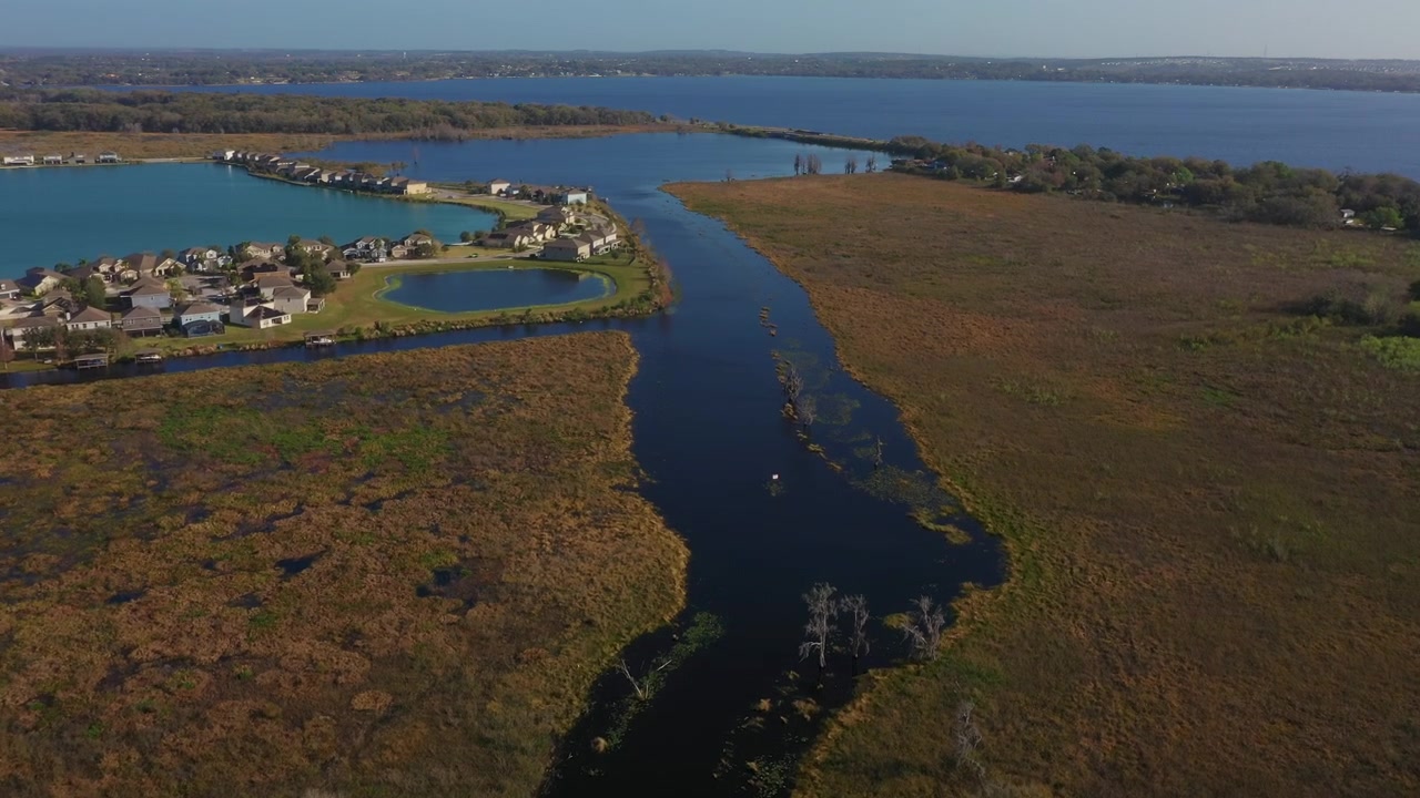 Vista aerea del fiume Palatlakaha che serpeggia attraverso Clermont, Florida, collegando una comunità residenziale al lago Minneola sotto il ponte dell'autostrada 50