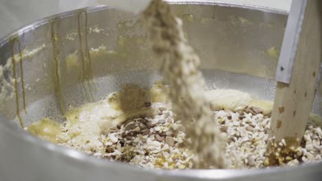 toma de cámara lenta de una olla de mezcla con varios ingredientes para dulces caseros que se mezclan en una masa o masa