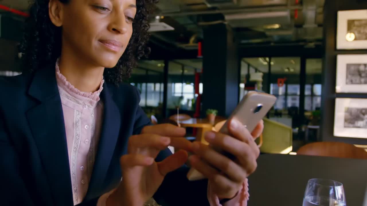 Animation of network of connections with media icons over biracial woman using smartphone