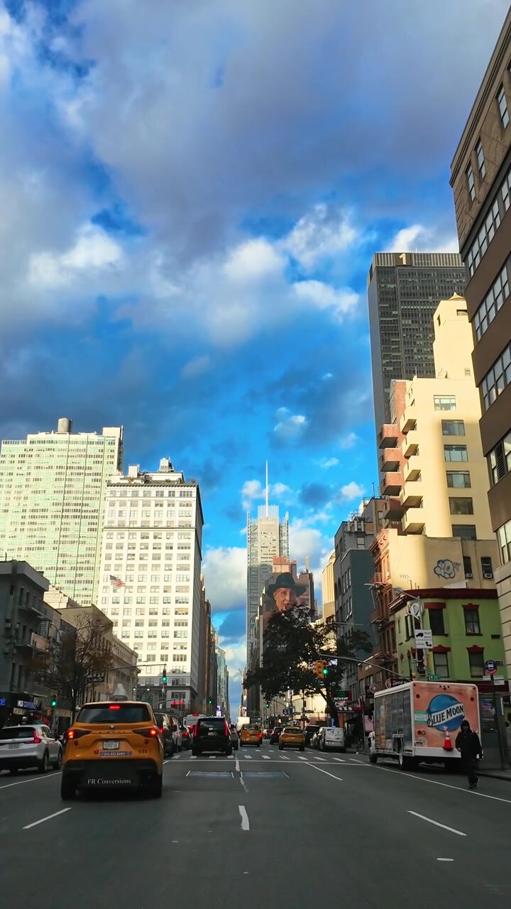 New York, USA, 25 agosto 2025: Traffico a Midtown Manhattan al tramonto. Affollata strada di Midtown Manhattan con auto e grattacieli sotto drammatiche nuvole serali