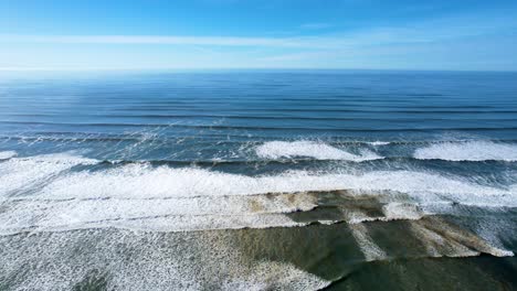 4k aerial drone shot floating above ocean tide at seaside, oregon beach