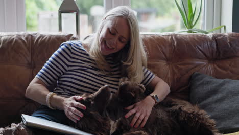 woman cuddling dog on couch