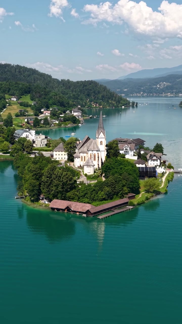 Ripresa verticale con drone della Chiesa Cattolica a Maria Wörth, Austria. Punto di riferimento del villaggio sul Lago Wörthersee in una soleggiata giornata estiva.