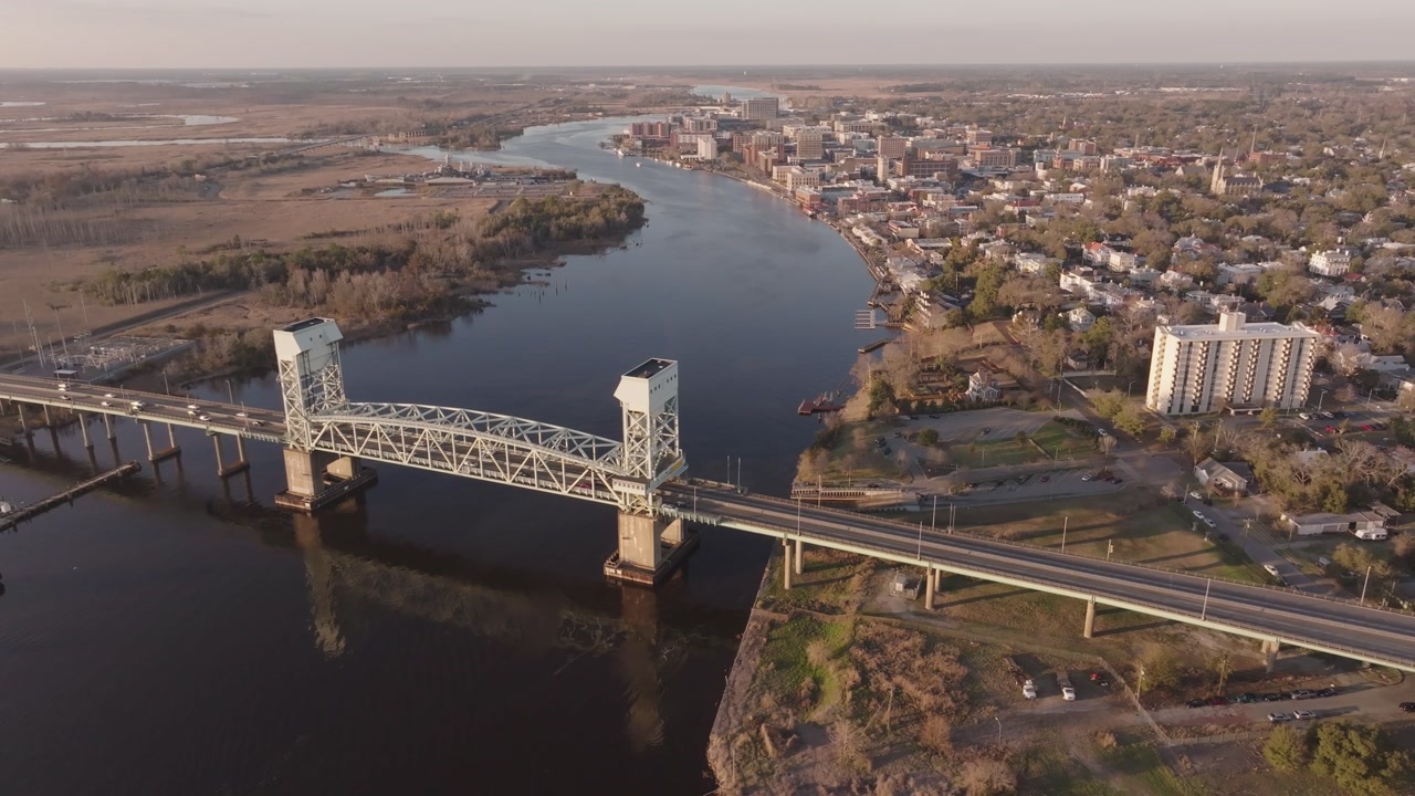 A 4k drone shot tracking around a bridge near a coastal town in North Carolina at sunset