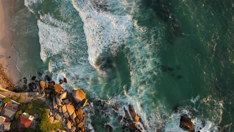 Vista-Aérea-De-Arriba-Hacia-Abajo-Del-Hermoso-Océano-Azul-Turquesa-En-La-Playa-De-Camps-Bay,-Ciudad-Del-Cabo