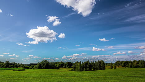 White-cumulus-clouds-develop-in-a-bright-blue-sky-over-a-green-landscape