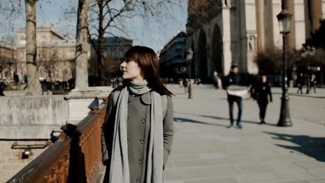 happy peaceful beautiful woman walking alone near notre dame de paris square enjoying sunny autumn day slow motion.