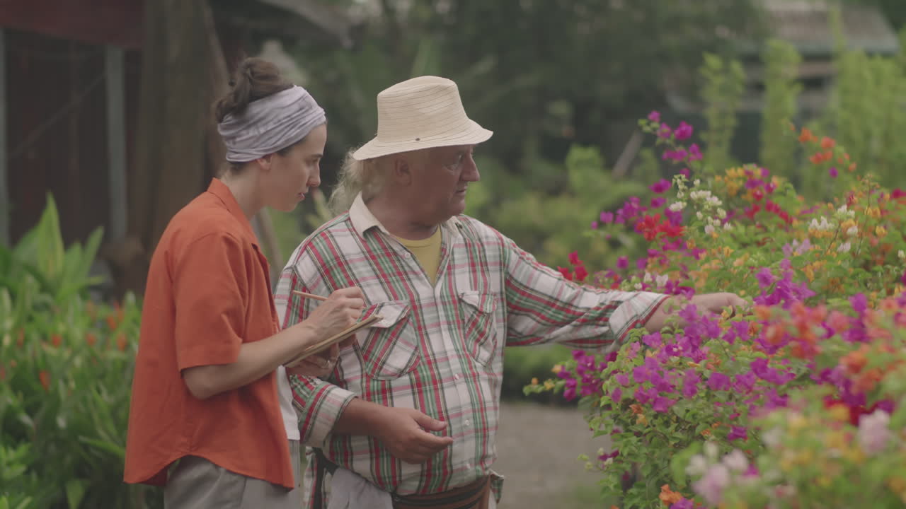 Nurseryman Discussing Plants with Female Colleague in Garden