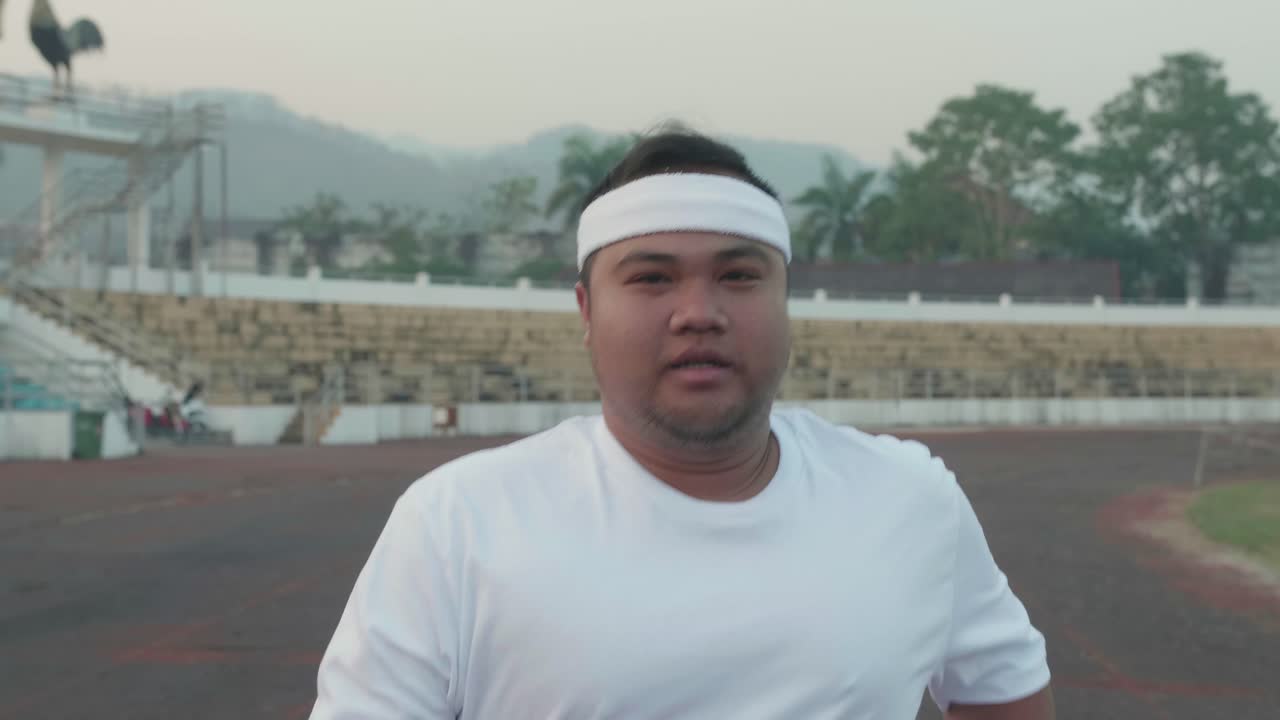 Overweight Man Jogging At Stadium
