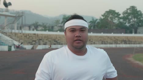 overweight man jogging at stadium