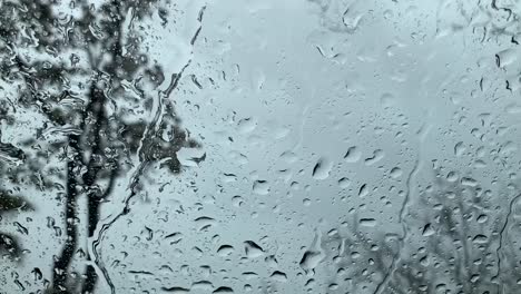 Raindrops-falling-onto-a-clear-glass-window-forming-streaks-like-tears-on-a-gloomy-day