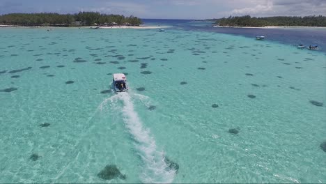 crystal clear blue waters of mauritius island on vacation, with a tourist motor boat gliding through the ocean waters