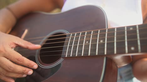 Nahaufnahme-In-Zeitlupe-Mit-Den-Händen-Eines-Mädchens,-Das-Bei-Sonnenuntergang-Gitarre-Spielt