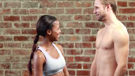 una pareja en forma hablando en el gimnasio de crossfit.