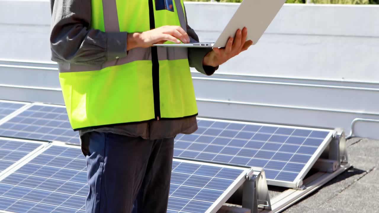 Male worker using laptop at solar station 4k