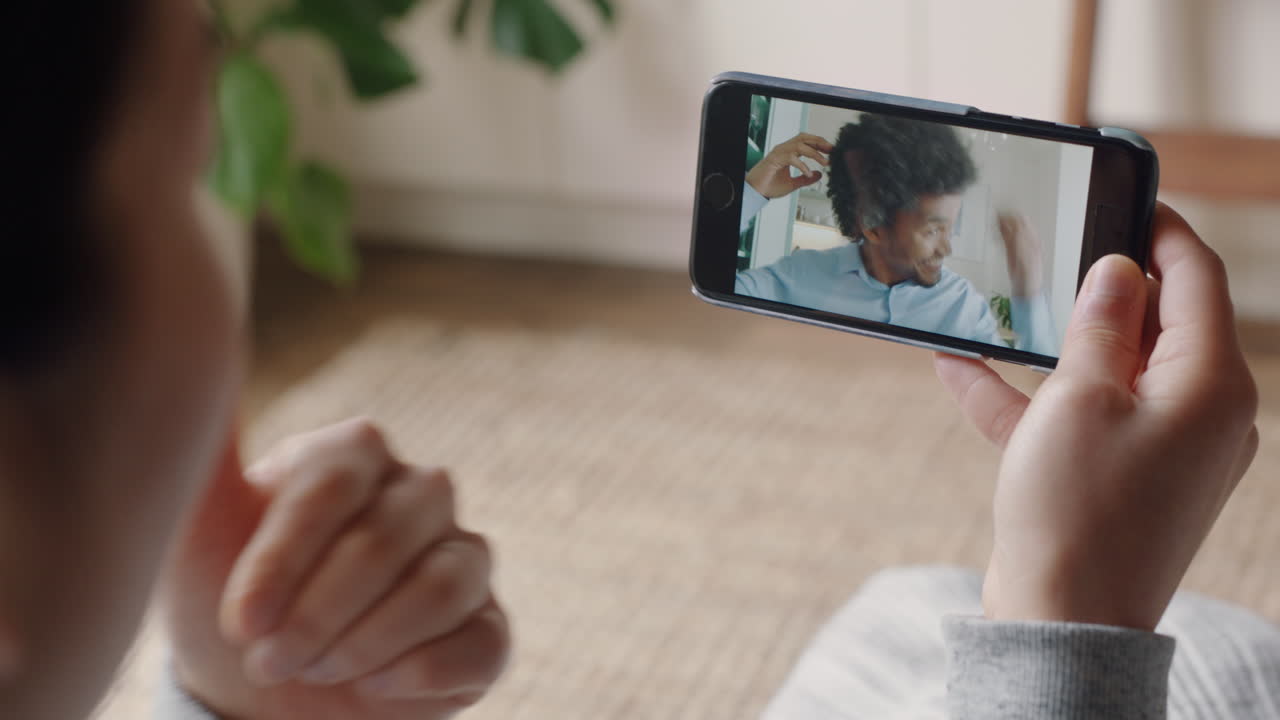 mujer joven teniendo video chat usando smartphone en casa hablando con su novio mostrando su peinado compartiendo estilo de vida disfrutando de una relación a larga distancia